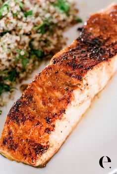 a white plate topped with salmon and rice