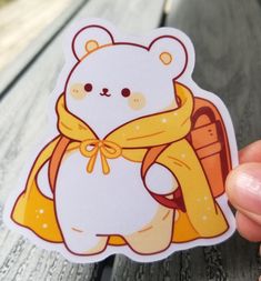 a person holding up a sticker with a bear on it