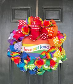 a colorful wreath on the front door with love out loud written on it and polka dots