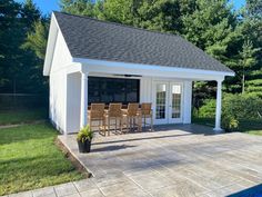 a pool house with a table and chairs next to it