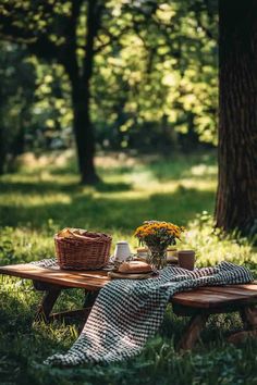 a picnic table in the middle of a park with flowers on it and a blanket draped over it