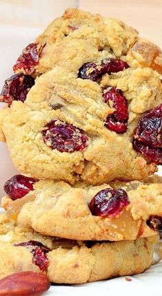 three cookies stacked on top of each other with cranberries and almonds in the middle