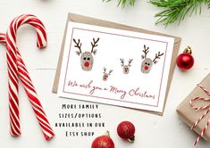 christmas card with two reindeer heads and candy canes on the table next to it