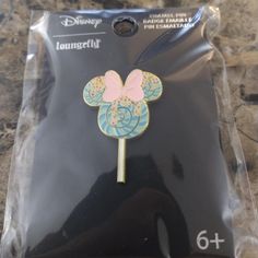 a disney mouse pin with a pink bow on it's head in a package