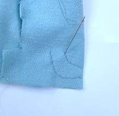 the sewing needle is being used to sew on the top of a blue t - shirt