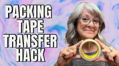 a woman holding up a yellow and black object with the words packing tape transferer hack