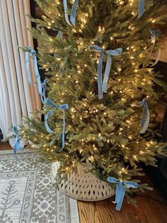 a decorated christmas tree with blue ribbon and lights