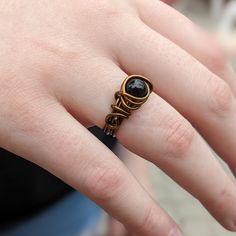 Black onyx ring wire wrapped in non tarnish antique brass plated wire. The stone is 6mm. Made to order in your size and comes in a gift box. Since each ring is handmade and gemstones vary in color tone and pattern, there may be slight differences in each ring. To insure your plated rings last a long time, avoid washing your hands with hash soaps, using chemicals, and participating in strenuous activity while wearing your rings. Ring may appear larger in photos to show detail. Lead and nickel fre Black Brass Rings For Gift, Black Round Copper Jewelry, Black Copper Round Jewelry, Earthy Rings, Earth Tone Jewelry, Rhodonite Ring, Wire Wrapped Jewelry Tutorials, Earthy Jewelry, Ring Wire