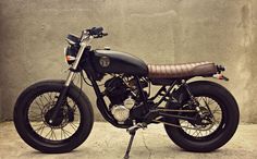 a black and brown motorcycle parked in front of a wall