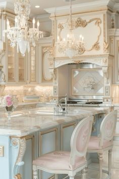 an elegant kitchen with chandelier and marble counter tops, white cabinets and pink chairs