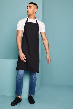 a man wearing an apron standing in front of a blue wall