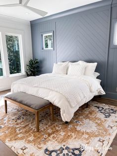 a large bed sitting on top of a wooden floor next to a window in a bedroom