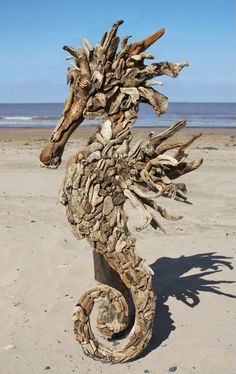 a sea horse made out of driftwood on the beach