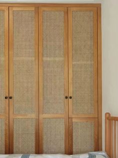 a wooden armoire sitting next to a bed