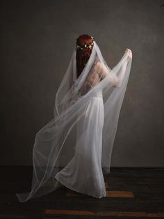 a woman in a white dress with a veil on her head