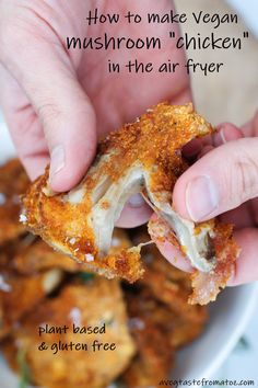 someone is holding up a piece of chicken in front of some fried food on a plate