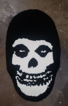 a black and white knitted skull mask on the ground