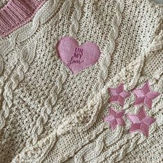 two knitted sweaters with hearts and stars on them