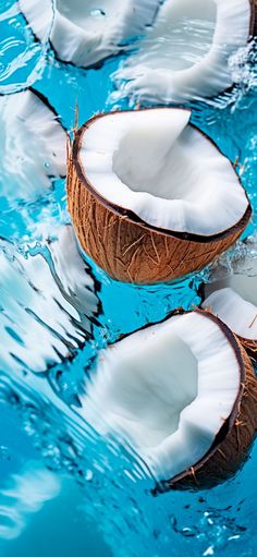 three coconuts floating in the water with one cut open