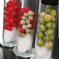 three glass vases filled with different types of fruits and veggies in them