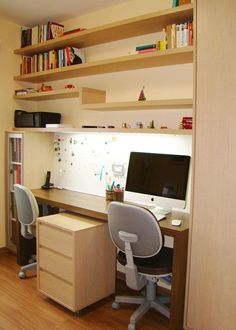 a desk with a computer on top of it in front of a bookshelf