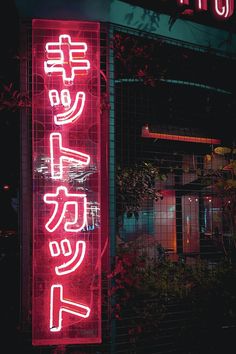 a red neon sign that is on the side of a building