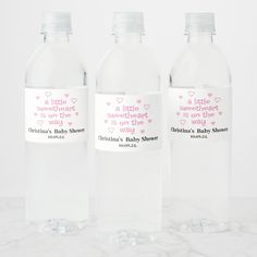 three water bottles with baby shower labels on them