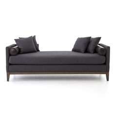 a gray couch with two pillows on top of it and one arm folded back to the side