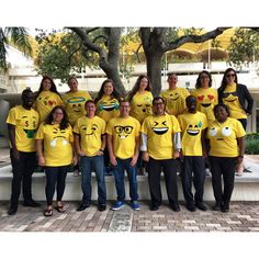 a group of people in yellow shirts standing next to each other on a brick walkway