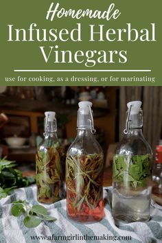 three glass bottles filled with herbs sitting on top of a table next to green plants