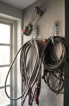 there are many cords hanging on the wall next to each other and wires attached to the wall