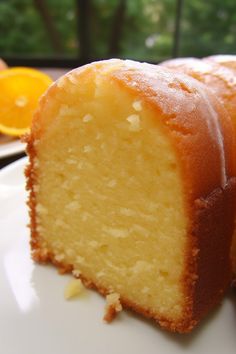 a piece of cake sitting on top of a white plate next to an orange slice