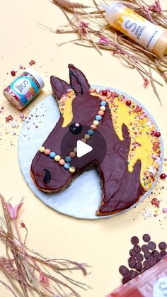 a horse shaped cake sitting on top of a table next to candy and other items