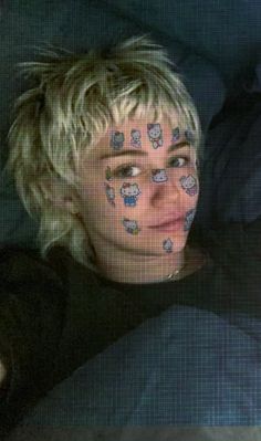 a woman with her face painted in hello kitty on her forehead and eyes covered by cat stickers