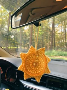 a car dashboard with a yellow sun decoration hanging from it's dash board in the front seat