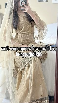 a woman in a wedding dress taking a selfie with her cell phone while wearing a veil