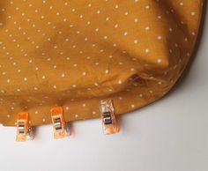 three small clips are attached to a yellow polka dot bag