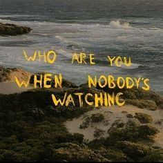 the words who are you when nobody's watching written in yellow ink on an ocean background