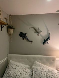 a bed with two pillows and some seagulls hanging on the wall above it