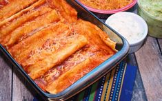 an image of food that is in the pans on the wooden table and ready to be eaten