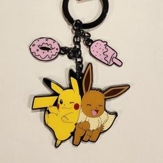 two pikachu and donut shaped keychains on a white table top