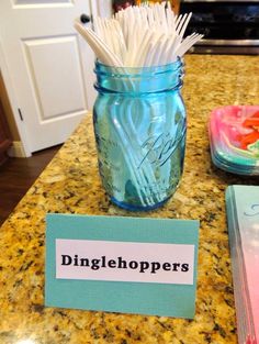 a blue mason jar filled with toothbrushes on top of a counter next to a sign