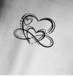 a heart tattoo on the back of a woman's arm, with swirls and hearts