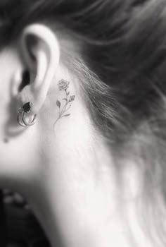 black and white photo of a woman's behind the ear with flowers on it