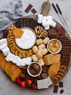 a platter filled with cookies, marshmallows, crackers and chocolate