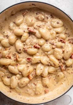 a pot filled with pasta and sauce on top of a table