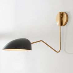 a black and gold wall light on a white wall