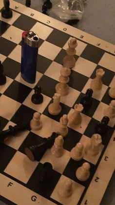 a chess board with pieces on it and a lighter in the middle next to it