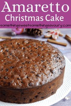 a chocolate cake sitting on top of a white plate with the words amarettoo christmas cake