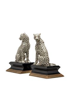 two statues of cheetah sitting on top of books